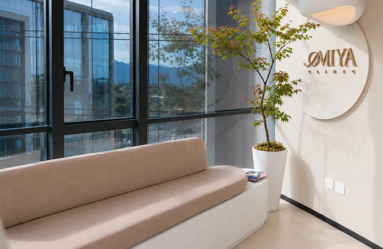 Recepción de Omiya Clinic: un momiji junto al muro con el logo de bronce